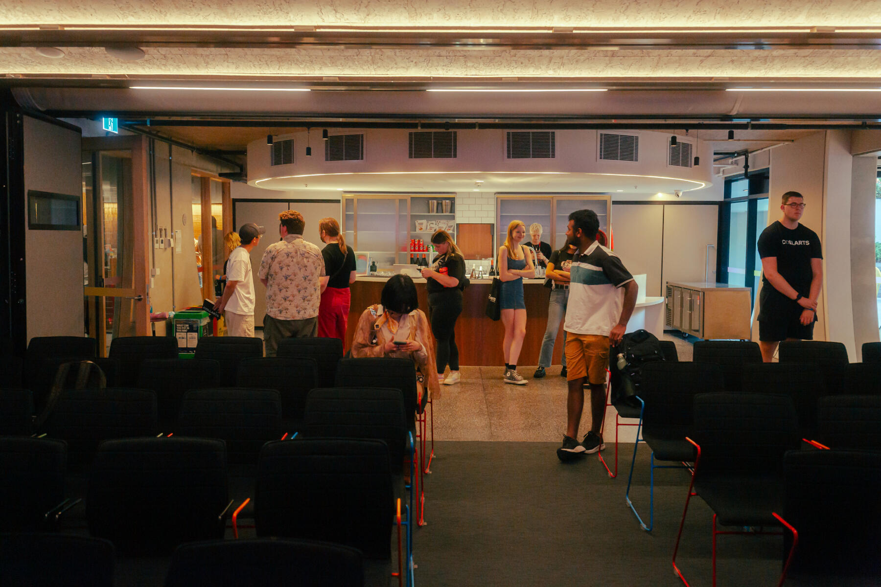 Untitled People standing around a bar before a panel event