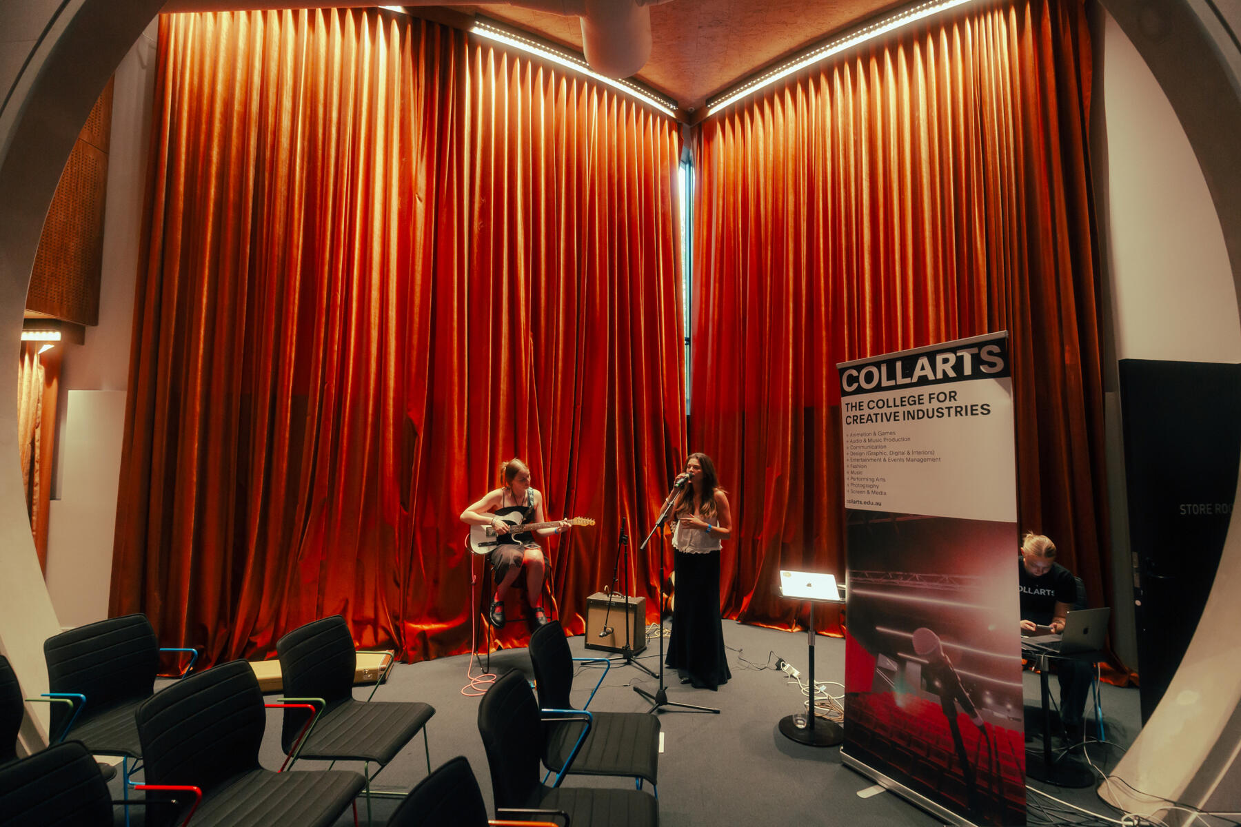 Untitled A female singer and female guitarist performing at a panel event